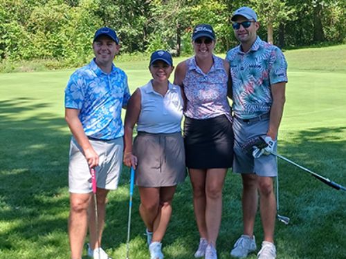 4 golfers posing on course